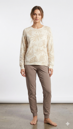 Woman wearing a beige patterned top and brown pants on a white background