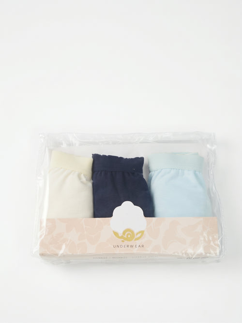 A three-pack of women's underwear in a clear plastic clamshell package with a beige paper band. The pack contains a cream-colored pair, a dark navy pair, and a light blue pair, with a central white label showing a gold logo and the word 'UNISEX'.