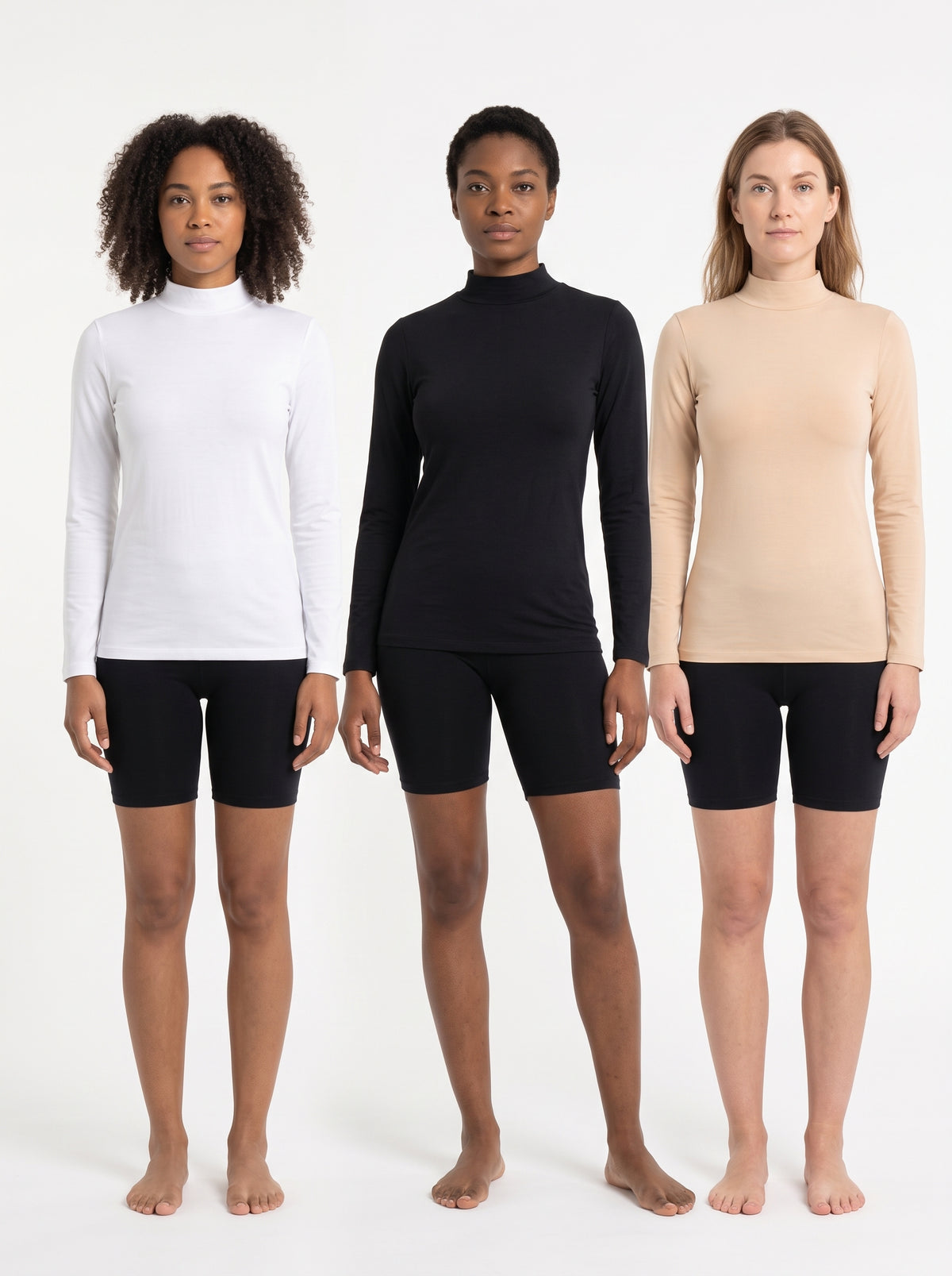 Three models standing side by side wearing long-sleeve mock neck athletic tops in white, black, and beige, paired with black biker shorts, against a plain white studio background.