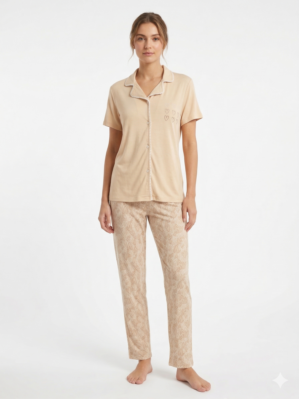 Woman wearing beige pajama set on a white background